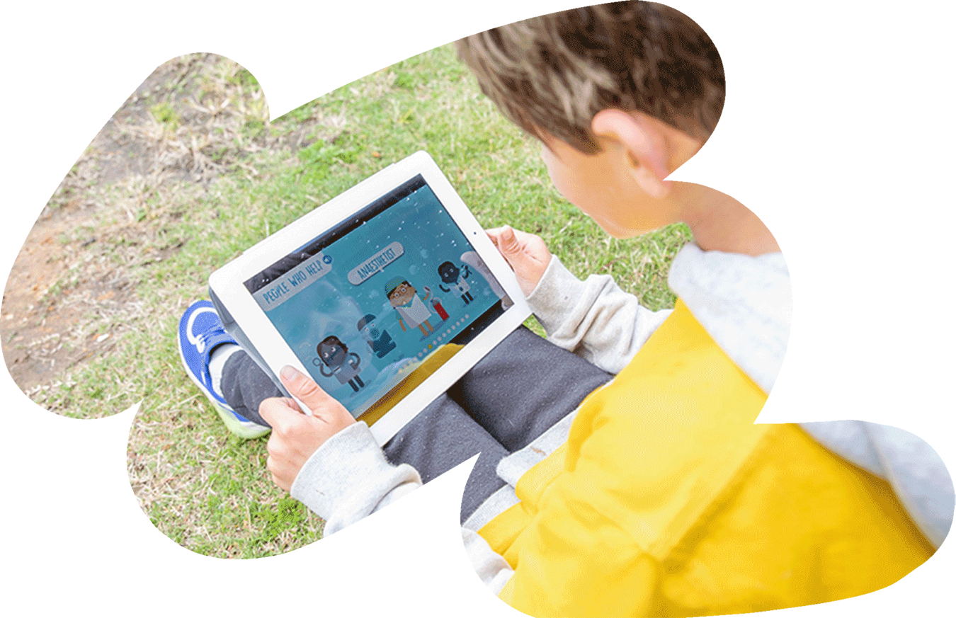 A young boy looks at the Kids' Guide to Cancer app on his tablet device