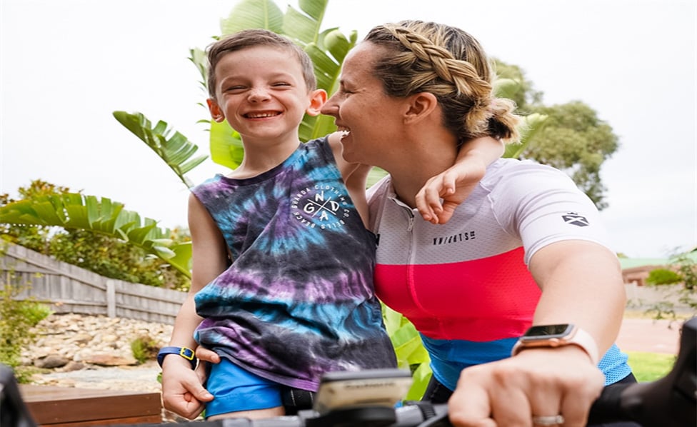 Boy and mother on bike laughing while looking at each other
