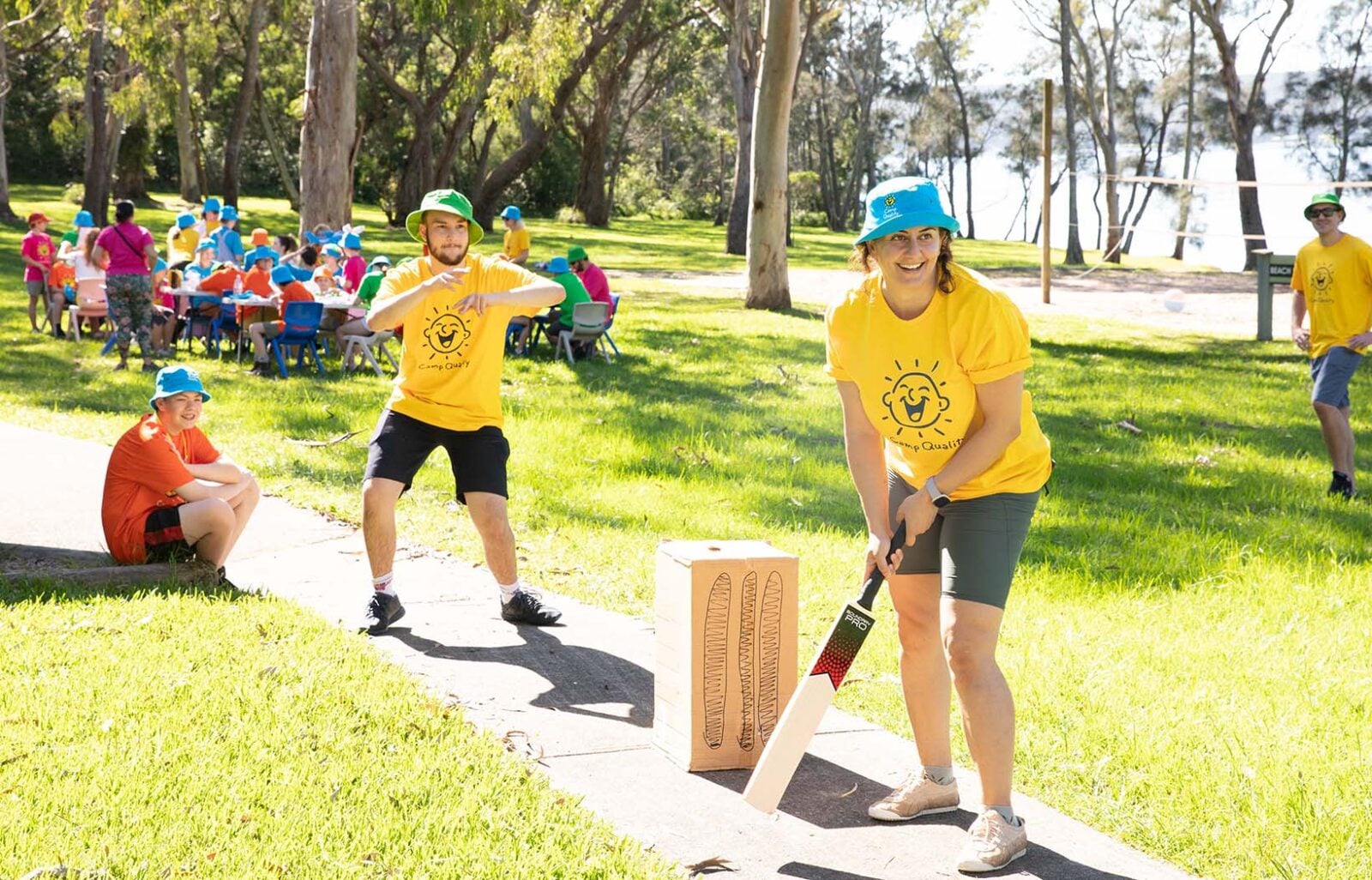 Camp Quality volunteers play a game of backyard cricket