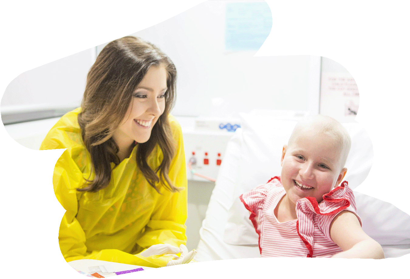 A Child Life Therapist sits at a child's bedside in hospital