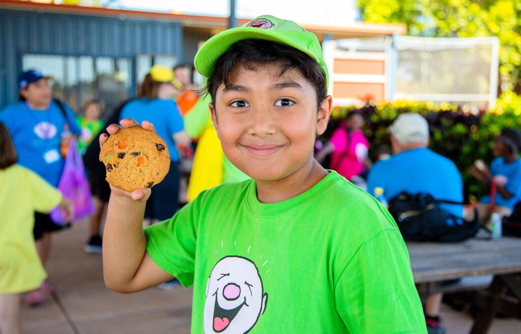 Child smiling while holding cookie