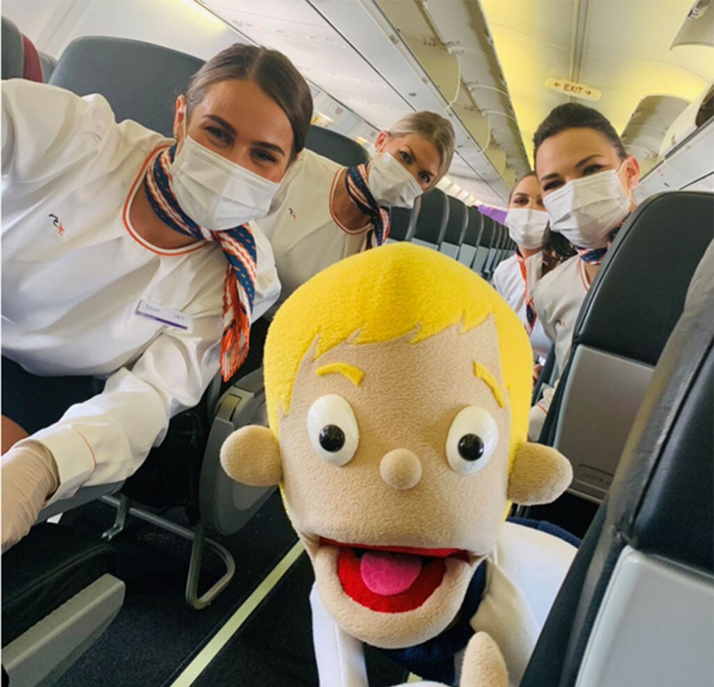 Flight attendants posing with Camp Quality puppet