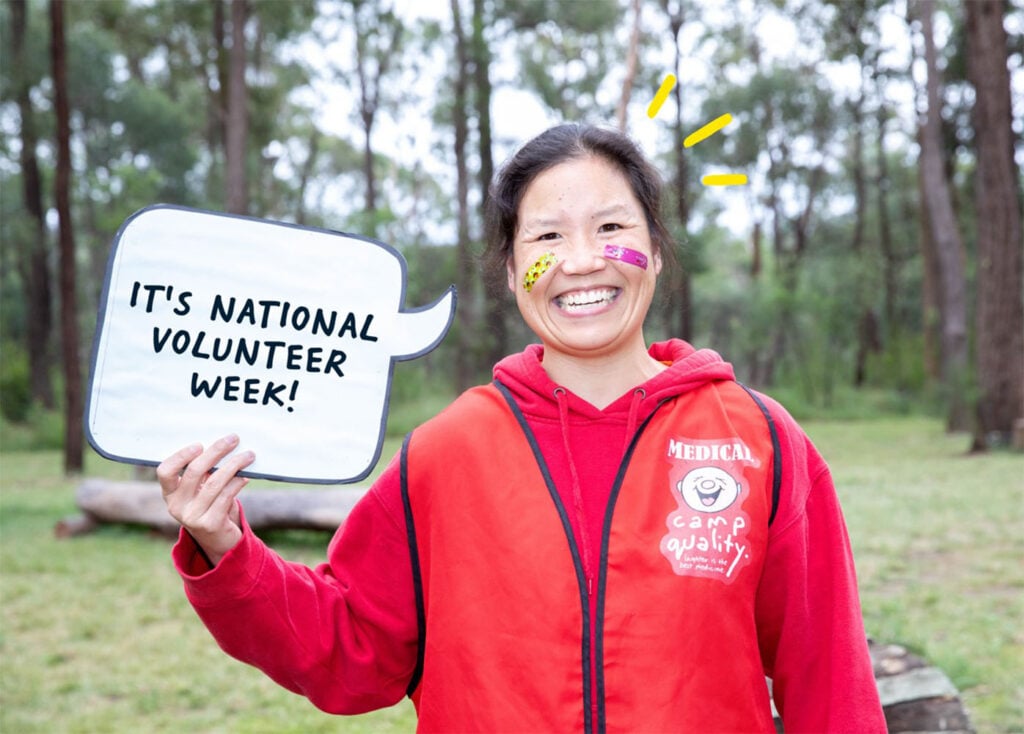 Susan smiling while holding sign saying 'It's national volunteer week'