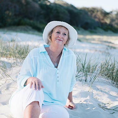Sue, who has left Camp Quality a bequest, sits on the beach