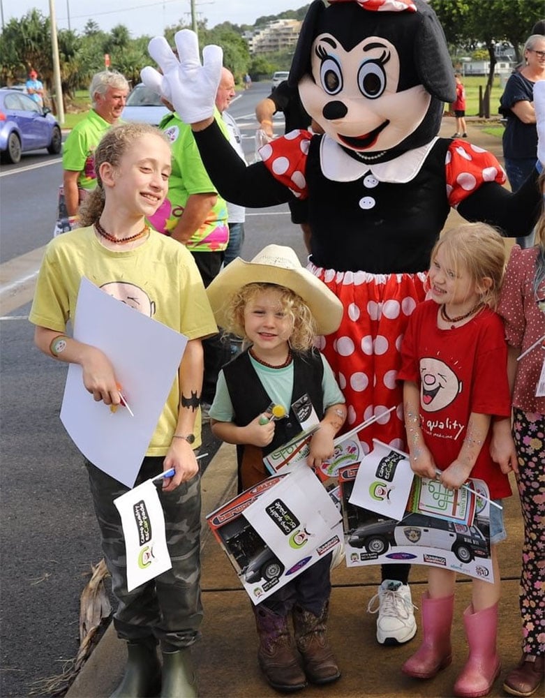 Children smiling with person in Minnie Mouse costume