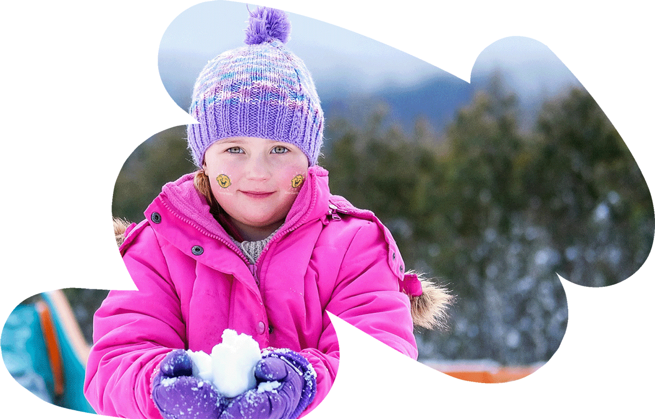 A young girl holds a snowball