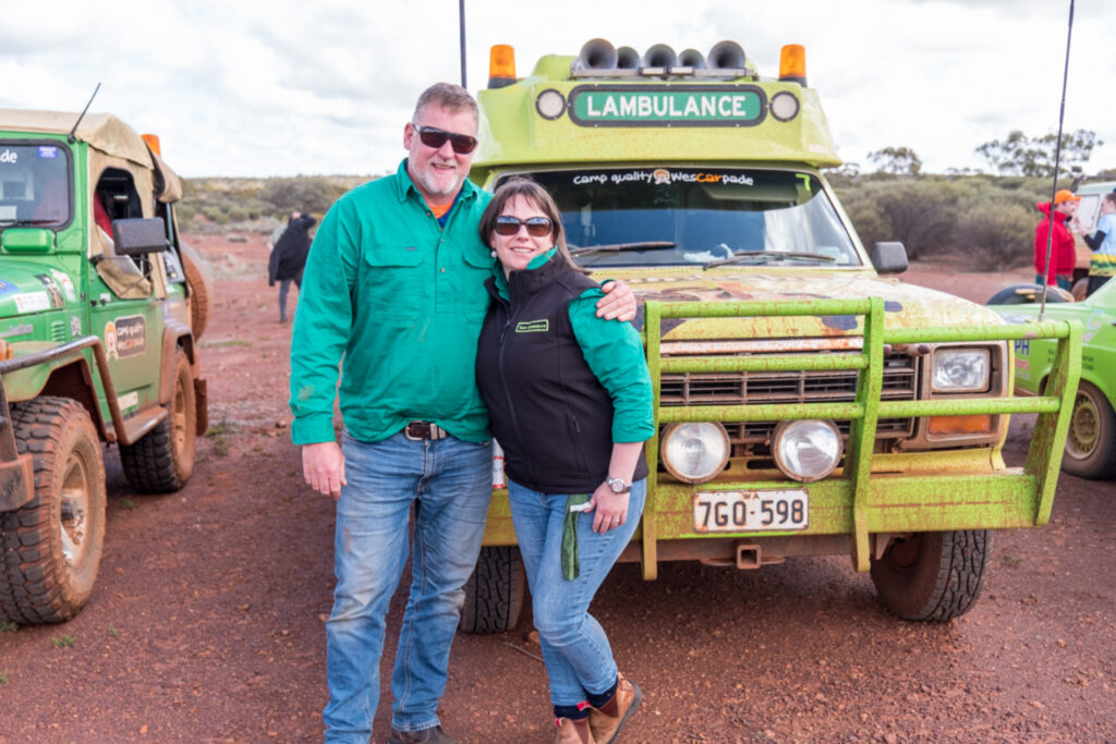Couple smiling in front of a green truck