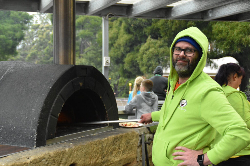 A Camp Quality vollie next to a pizza oven