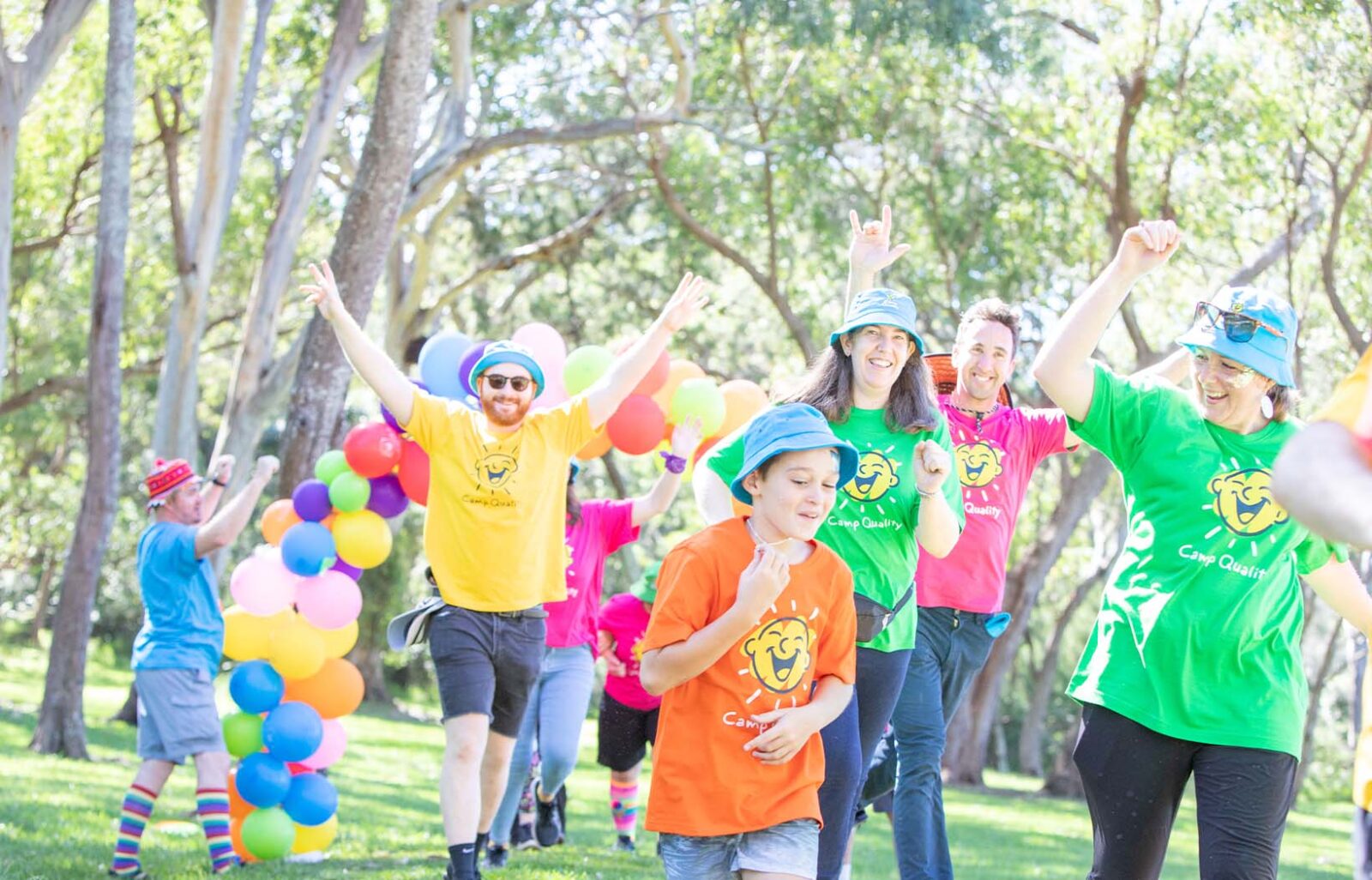Volunteers and Camp Quality children running together