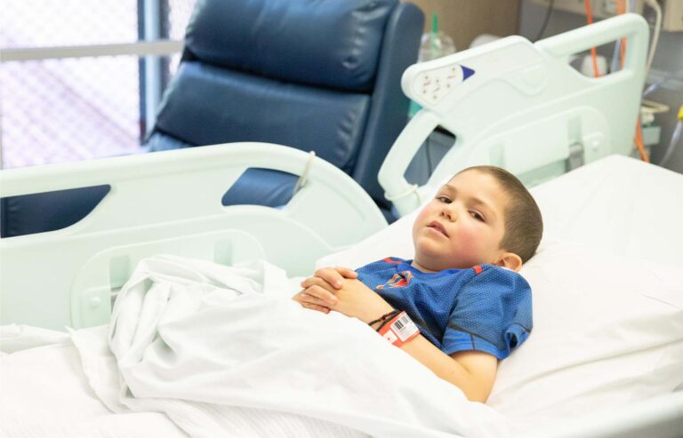 Camp Quality child lying in hospital bed